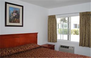 a hotel room with a bed and a window at Rose Bowl Motel in Los Angeles