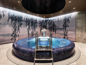 a jacuzzi tub in a room with a painting at Sheraton Sopot Hotel in Sopot