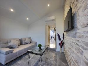 a living room with a couch and a stone wall at Le cosy 2 personnes in Oslon