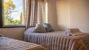 1 dormitorio con 1 cama con ventana y asiento junto a la ventana en Patagonia Residence en Trelew
