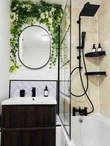 bagno con lavandino, specchio e doccia di Hidden Oasis Comfy Studio in New Cross London a Londra