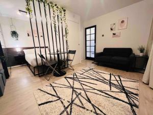 a living room with a black couch and a rug at Hidden Oasis Comfy Studio in New Cross London in London