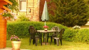 a table with chairs and an umbrella in a yard at Ferienwohnung Nele in Federow
