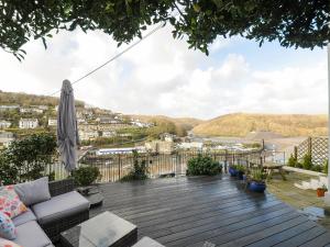 a deck with an umbrella and a view of a city at Elmbank in Looe