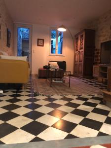 a living room with a black and white checkered floor at Cosy house in Casteljaloux