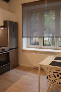 a kitchen with a table and a stove and windows at City Apartment Rudolf 26m2 in Graz