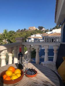 una mesa con un bol de fruta y una copa de vino en Bungalow Elena Casanova, en Calpe