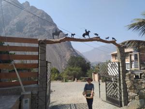 Une fille debout devant une porte avec des singes sur une branche dans l'établissement Cabaña en Fundo Huabayor, à Lima