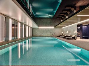 a swimming pool with blue water in a building at Sheraton Sopot Hotel in Sopot