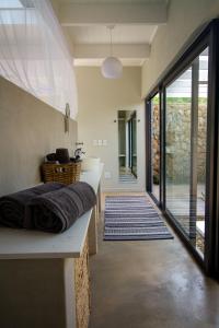 een kamer met een bed en een badkamer met een raam bij Ungava Retreat in Marloth Park