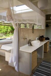 a bathroom with a sink and a bed at Ungava Retreat in Marloth Park