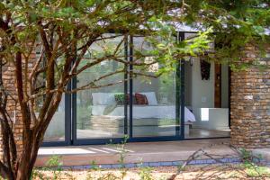 uma casa de vidro com uma cama dentro em Ungava Retreat em Marloth Park