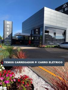 a car dealership in front of a building at Hotel Matrix in Apucarana