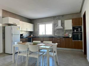 a kitchen with a white table and white chairs at Saf-Saf Apartement 1 in La Marsa