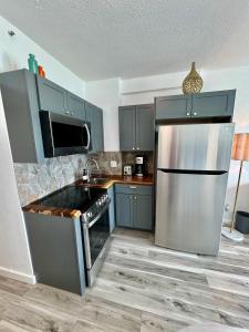 eine Küche mit blauen Schränken und einem Kühlschrank aus Edelstahl in der Unterkunft Directly on the Beach with Pool & Ocean View in Miami Beach