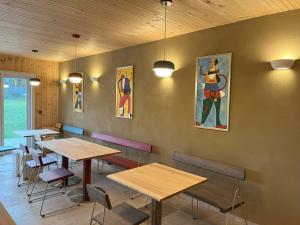 a restaurant with tables and chairs and paintings on the wall at B&B Zirbenduft in Ribnitz-Damgarten