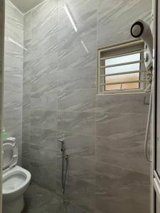 a bathroom with a toilet and a window at Camping Homestay Kluang in Kluang