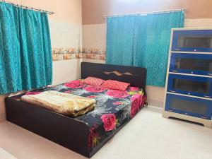 Un dormitorio con una cama con flores. en Peaceful Spacious Private 1BHK Near Airport close to VIP or Jessore Rd en Nagarbazar