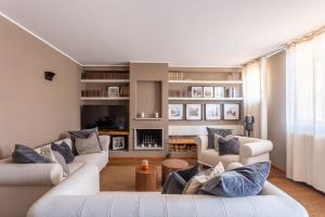 un soggiorno con 2 divani bianchi e cuscini blu di Suite Alzaia by iCasamia a Milano