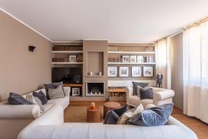 a living room with two white couches and blue pillows at Suite Alzaia by iCasamia it in Milan