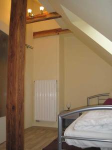 Zimmer im Dachgeschoss mit einem Bett und Holzbalken in der Unterkunft Ferienwohnung Borz in Bad Klosterlausnitz