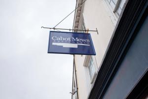 una señal azul en el lateral de un edificio en higgihaus Cabot Mews #40 Sunday - Friday Central Location, en Bristol