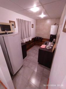 a small kitchen with a refrigerator and a table at La Cautiva 225 in Villa del Dique +2 photos