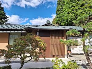 a house with a brown door and some trees at 和朗庵 