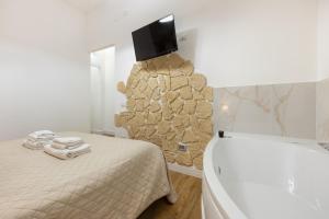 a bedroom with a bed and a tv on the wall at Fior Di Loto Rooms in Cagliari