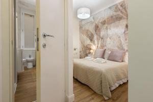 a bedroom with a bed with a painting on the wall at Fior Di Loto Rooms in Cagliari