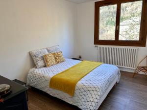A bed or beds in a room at Appartement au cœur des alpes