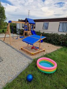 a playground with a table and a play equipment at Domki Paradiese in Jarosławiec