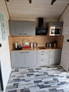 a kitchen with white cabinets and a counter top at Domki Paradiese in Jarosławiec