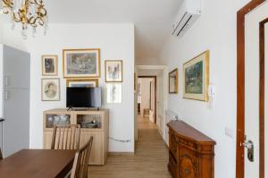 a dining room with a table and a tv on a wall at Casa degli artisti 1 in Casarza Ligure