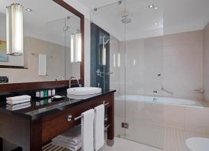 a bathroom with a sink and a shower and a tub at Sheraton Sopot Hotel in Sopot