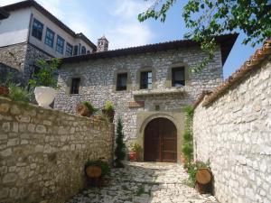 an old stone house with a stone wall at Hotel Klea in Berat
