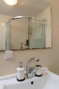 ein Waschbecken mit einem Spiegel und einem Wasserhahn in der Unterkunft Studio with sea view with Bomb Shelter in Tel Aviv