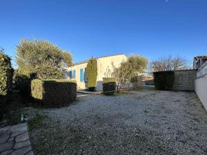 un patio con arbustos y un edificio con una valla en Maison Dolus-d'Oléron, 4 pièces, 6 personnes - FR-1-246A-158, en Dolus d'Oléron