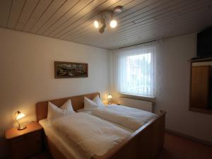 1 dormitorio con 1 cama con sábanas blancas y ventana en Ferienwohnung Pohl, en Bad Klosterlausnitz