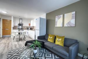 a living room with a couch and a kitchen at #24 Phoenix Court By DerBnB, Modern 2 Bedroom Apartment, Wi-Fi, Netflix & Within Walking Distance Of The City Centre in Sheffield