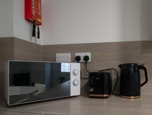 a microwave sitting on top of a counter next to a coffee mug at #24 Phoenix Court By DerBnB, Modern 2 Bedroom Apartment, Wi-Fi, Netflix & Within Walking Distance Of The City Centre in Sheffield