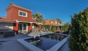 a house with a swimming pool in front of a house at Villa Venna, with a private pool in Baños y Mendigo
