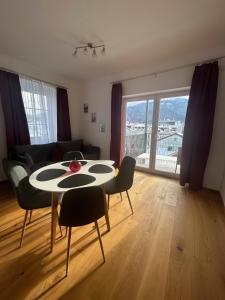 ein Wohnzimmer mit einem Tisch und Stühlen mit Aussicht in der Unterkunft CityLake G23 Apartments mit kostenlosem Parkgaragen-Stellplatz !! in Gmunden