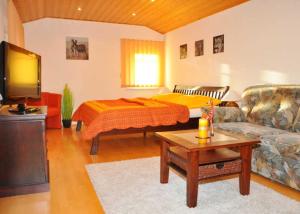 een woonkamer met een bed en een bank bij Ferienwohnung Plötner in Bad Klosterlausnitz