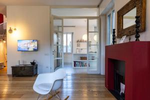 een woonkamer met een rode open haard en een witte stoel bij Villa Rossini - Autodromo F1 Villa Reale in Monza