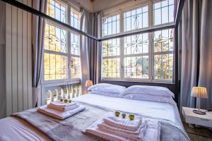 een slaapkamer met een bed met handdoeken en ramen bij Villa Rossini - Autodromo F1 Villa Reale in Monza