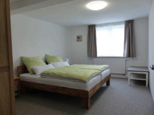 Un dormitorio con una cama con sábanas verdes y una ventana en Fewo E33 bei Peter, en Bad Klosterlausnitz