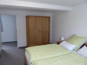 1 dormitorio con 1 cama y armario de madera en Fewo E33 bei Peter, en Bad Klosterlausnitz