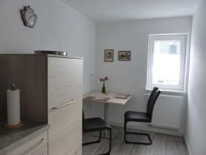 cocina con escritorio, mesa y sillas en Fewo E33 bei Peter, en Bad Klosterlausnitz