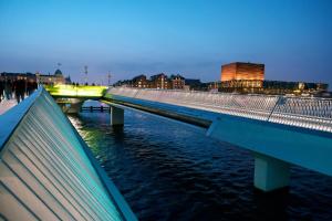un puente sobre un río con gente caminando sobre él en Spacious 3 Bedroom Flat in Peaceful Area, en Copenhague